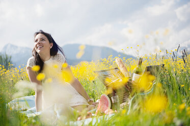 Young woman having picnic on alpine meadow - HHF005044