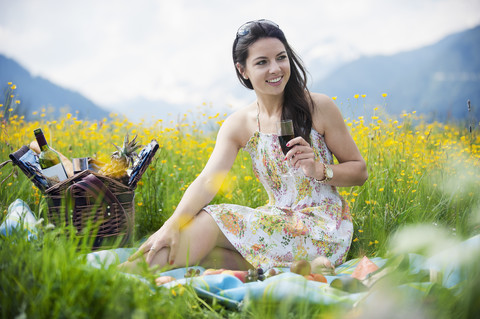 Junge Frau beim Picknick auf einer Bergwiese, lizenzfreies Stockfoto