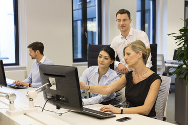 Geschäftsleute am Schreibtisch mit Blick auf den Computerbildschirm - SHKF000202