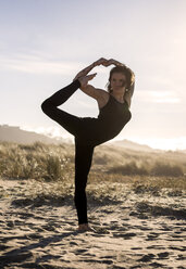 Spanien, Asturien, Aviles, Frau übt Yoga am Strand - MGOF000032