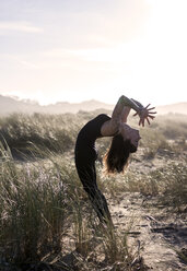 Spanien, Asturien, Aviles, Frau übt Yoga am Strand - MGOF000016