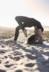 Spain, Asturias, Aviles, woman practicing yoga on the beach - MGOF000035