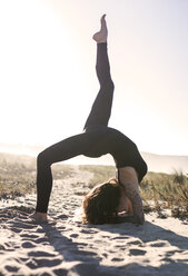 Spain, Asturias, Aviles, woman practicing yoga on the beach - MGOF000018