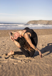 Spanien, Asturien, Aviles, Frau übt Yoga am Strand - MGOF000025
