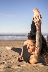 Spanien, Asturien, Aviles, Frau übt Yoga am Strand - MGOF000026