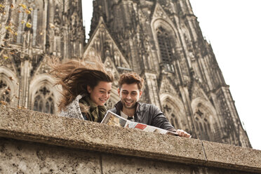 Deutschland, Köln, junges Paar betrachtet Stadtplan vor Kölner Dom - FEXF000236