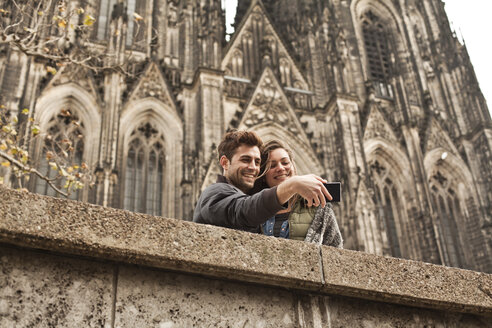 Deutschland, Köln, junges Paar beim Fotografieren vor dem Kölner Dom - FEXF000238