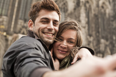 Germany, Cologne, young couple taking selfie in front of Cologne Cathedral - FEXF000239