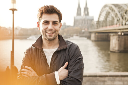 Germany, Cologne, portrait of smiling young man - FEXF000266