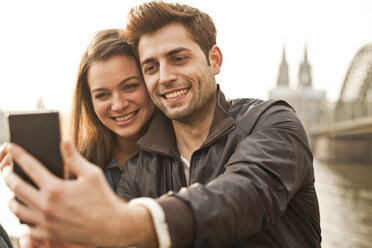 Germany, Cologne, young couple taking selfie - FEXF000275