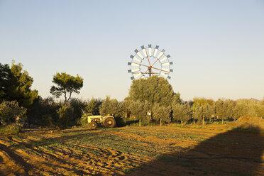 Spain, Balearic Islands, Majorca, Windmill and old tractor on a field - MEMF000666