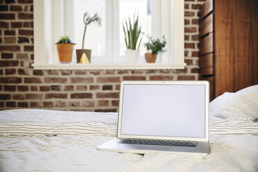 Laptop standing on bed - MFF001375