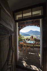 Austria, Salzburg State, Altenmarkt-Zauchense, woman enjoying breakfast on veranda of old farmhouse - HHF005053