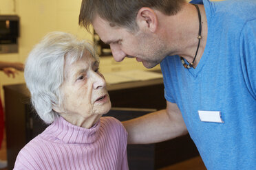 Altenpflegerin im Gespräch mit einer dementen Seniorin in einem Pflegeheim - DHL000509
