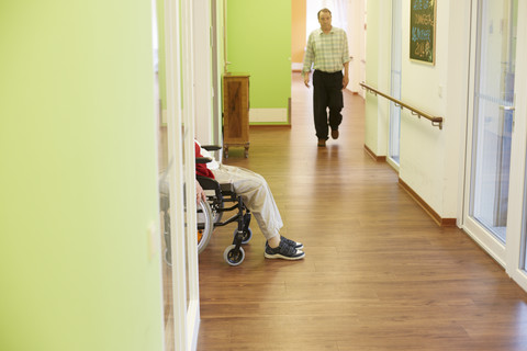 Alter dementer älterer Mann, der auf dem Flur eines Pflegeheims geht, lizenzfreies Stockfoto