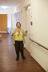 Demenzkranke Seniorin tanzt auf dem Flur eines Pflegeheims - DHL000520