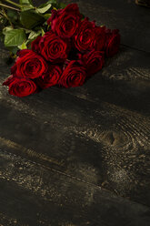 Rote Rosen auf dunklem Holz - MAEF009370