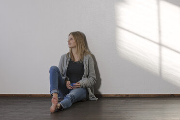 Young daydreaming woman sitting on floor - LAF001276