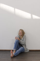 Laughing young woman with smartphone - LAF001277
