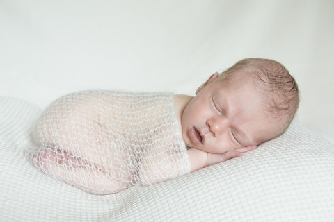 Porträt eines schlafenden Neugeborenen auf einer weißen Decke, lizenzfreies Stockfoto