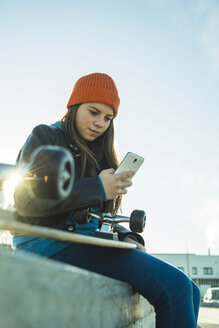 Teenage girl with cell phone in skatepark - UUF003037