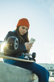 Teenager-Mädchen mit Handy im Skatepark - UUF003037