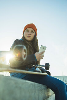 Teenage girl with cell phone in skatepark - UUF003038