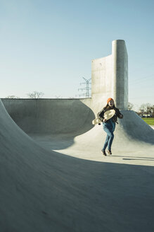 Teenage girl running in skatepark - UUF003041