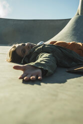 Teenager-Mädchen liegt im Skatepark - UUF003056