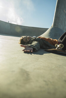 Teenage girl lying in skatepark - UUF003057