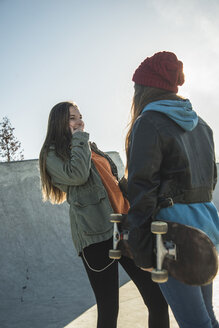 Two teenage girls in skatepark talking - UUF003080