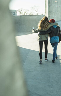 Two teenage girls embracing in skatepark - UUF003062