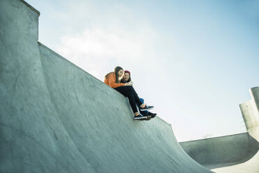 Zwei Teenager-Mädchen im Skatepark teilen sich ein Mobiltelefon - UUF003065