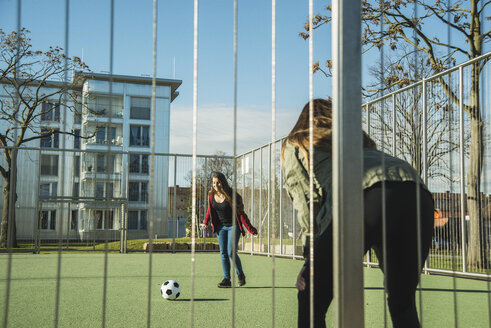 Two teenage girls on sports ground playing soccer - UUF003074