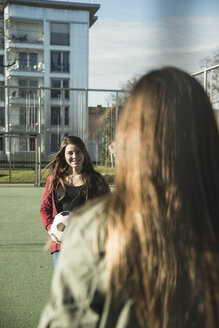 Two teenage girls with soccer ball on sports ground - UUF003075