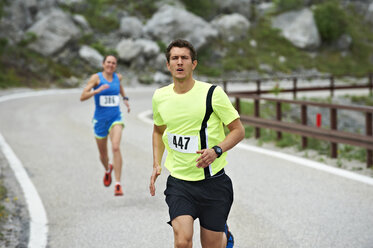 Italien, Trentino, Mann und Frau laufen bei einem Wettkampf in der Nähe des Gardasees - MRF001452