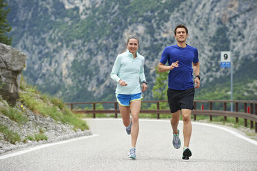 Italy, Trentino, couple running on road near Lake Garda - MRF001457