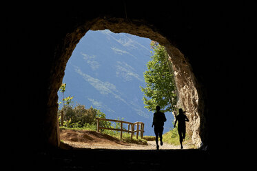 Italy, Trentino, couple running in tunnel near Lake Garda - MRF001465