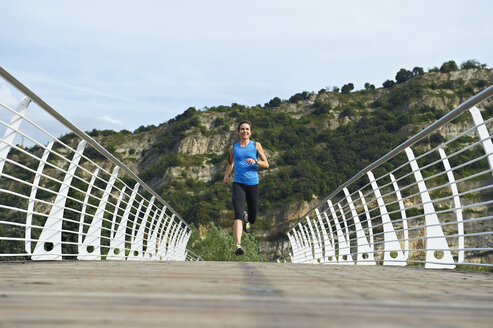 Italien, Trentino, Frau läuft auf Fußgängerbrücke in der Nähe des Gardasees - MRF001479