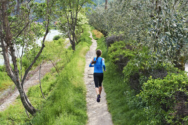 Italy, Trentino, woman running near Lake Garda - MRF001481