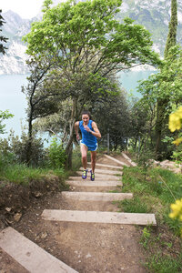 Italien, Trentino, Frau läuft auf Treppe am Gardasee - MRF001483