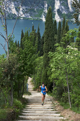 Italien, Trentino, Frau läuft auf Treppe am Gardasee - MRF001484