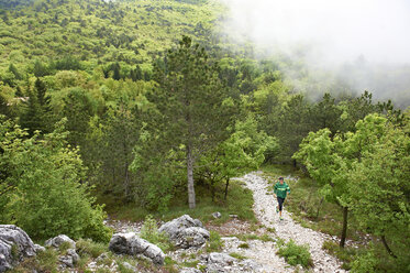 Italy, Trentino, man running in forest near Lake Garda - MRF001493