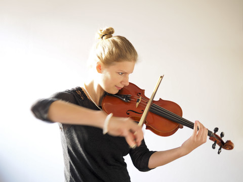 Junge Frau spielt Geige, lizenzfreies Stockfoto