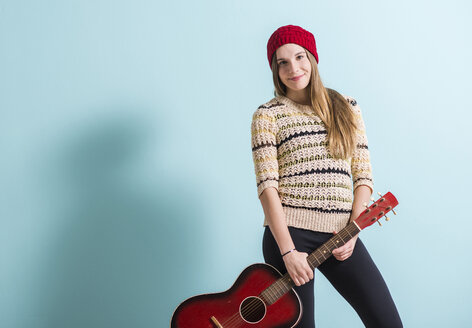 Lächelnder weiblicher Teenager mit Gitarre - UUF003154