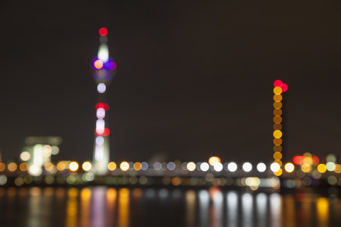 Deutschland, Düsseldorf, unscharfe Ansicht von Rheinturm und Brücke bei Nacht, lizenzfreies Stockfoto