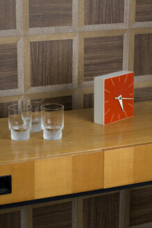 Sideboard with glasses and watch in front of wooden wall cladding - PATF000022