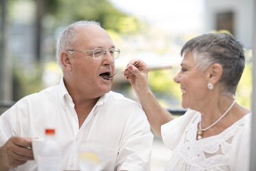 Wife feeding husband some cake - ZEF003744