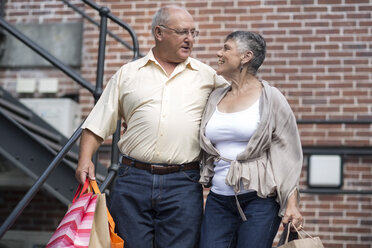 Glückliches Seniorenpaar mit Einkaufstüten - ZEF003749