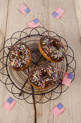 Drei amerikanische Cronuts mit Schokoladenglasur und Zuckerkonfetti, lizenzfreies Stockfoto